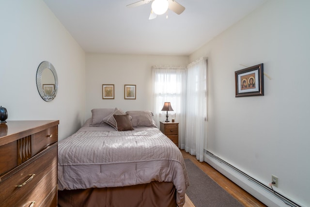 bedroom featuring wood-type flooring, a baseboard radiator, and ceiling fan