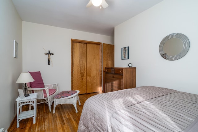 bedroom featuring hardwood / wood-style flooring, ceiling fan, and a closet