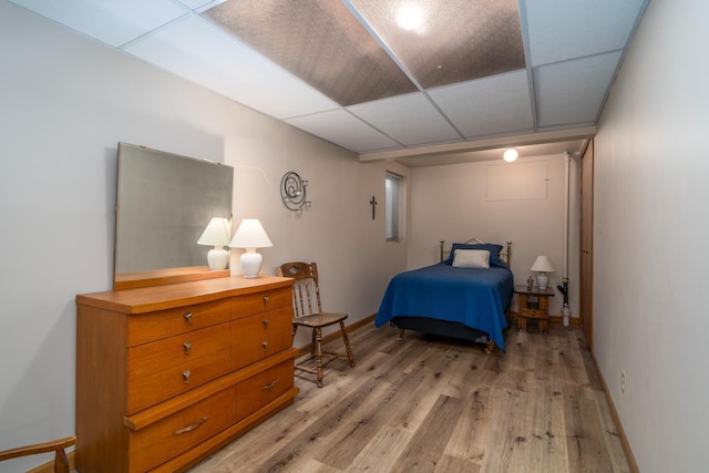 bedroom with light hardwood / wood-style floors and a drop ceiling