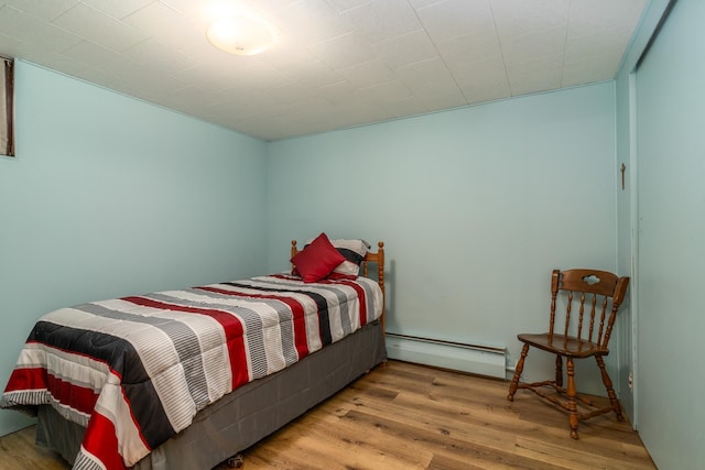 bedroom featuring a baseboard radiator and light hardwood / wood-style flooring