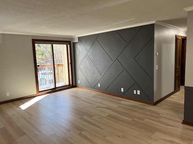 spare room featuring crown molding, light hardwood / wood-style floors, and a textured ceiling