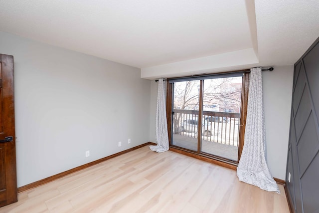 unfurnished room with baseboards and light wood-style floors