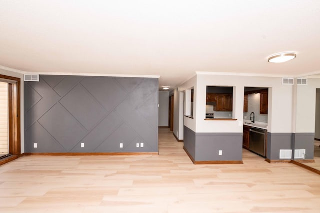 unfurnished living room featuring visible vents, ornamental molding, and light wood-style flooring