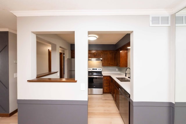 kitchen with visible vents, under cabinet range hood, light countertops, appliances with stainless steel finishes, and a sink