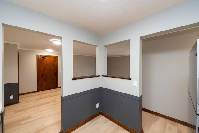 hall with baseboards and light wood finished floors