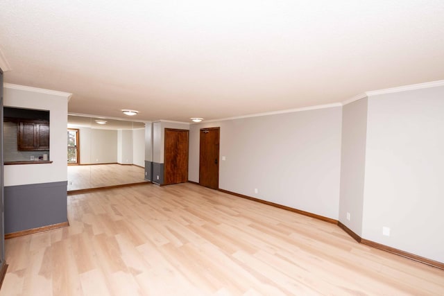 empty room with light wood finished floors, baseboards, and ornamental molding