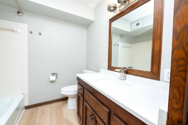 full bathroom with vanity, washtub / shower combination, wood finished floors, visible vents, and toilet