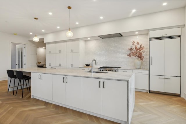 kitchen featuring a large island, white cabinetry, paneled fridge, backsplash, and pendant lighting