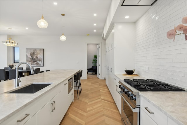 kitchen with appliances with stainless steel finishes, hanging light fixtures, and white cabinetry