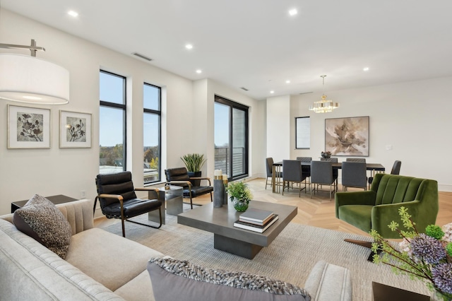 living room with light parquet floors and a notable chandelier