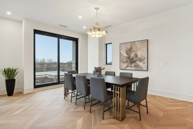 dining room with light parquet flooring and an inviting chandelier