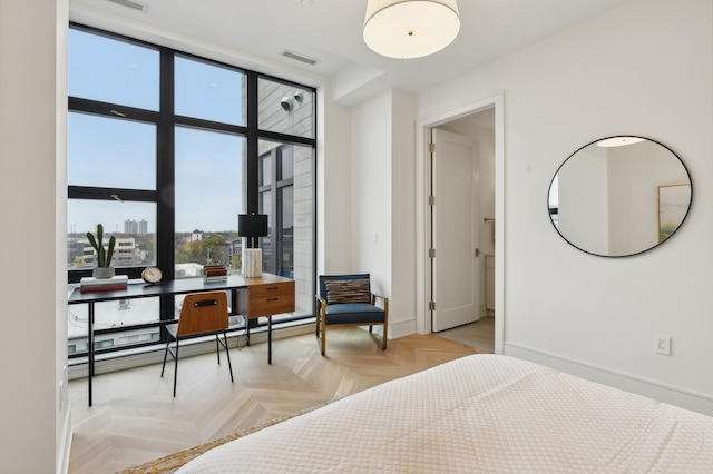 bedroom with a baseboard radiator, expansive windows, and light parquet floors