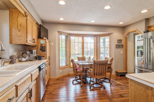 kitchen featuring a textured ceiling, light brown cabinets, dark hardwood / wood-style flooring, and stainless steel appliances