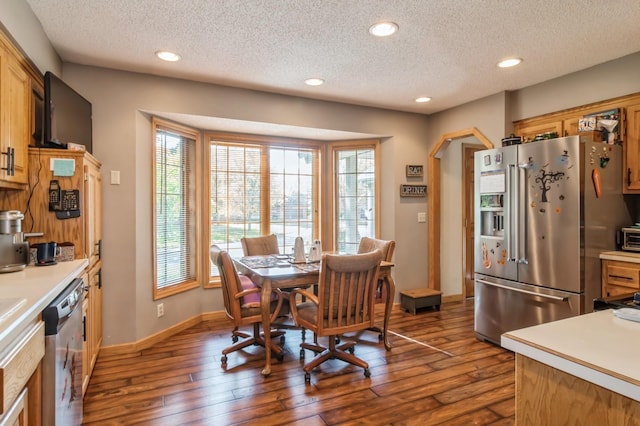 dining space with dark wood-type flooring and a textured ceiling