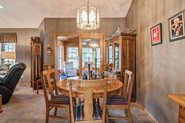 carpeted dining area with a chandelier