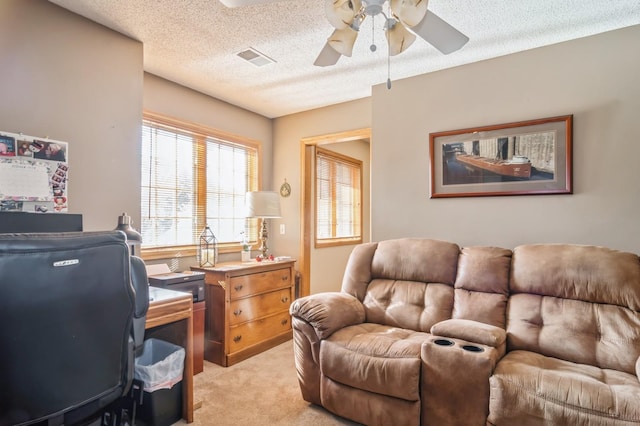 office featuring a textured ceiling, light colored carpet, and ceiling fan