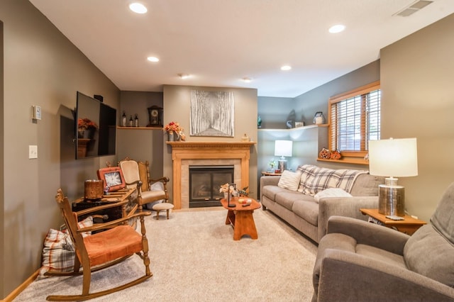 carpeted living room with a tiled fireplace