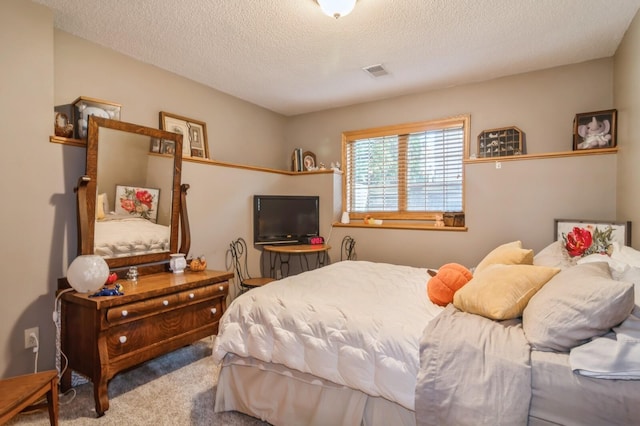 bedroom with light carpet and a textured ceiling