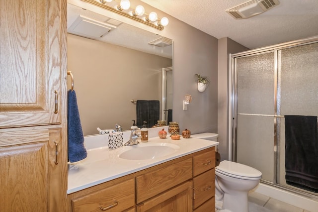 bathroom with walk in shower, tile patterned flooring, a textured ceiling, toilet, and vanity