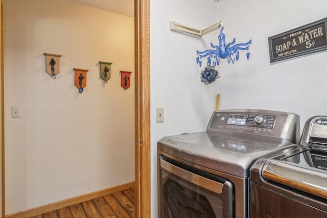 clothes washing area with washer and dryer, a textured ceiling, and hardwood / wood-style flooring