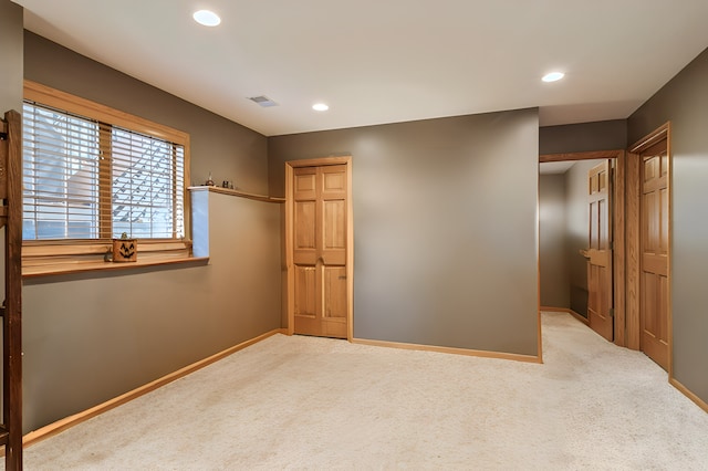 unfurnished bedroom featuring light carpet and a closet