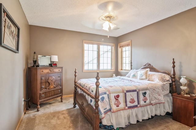 bedroom with light carpet, a textured ceiling, and ceiling fan