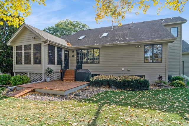 back of house with a sunroom and a lawn