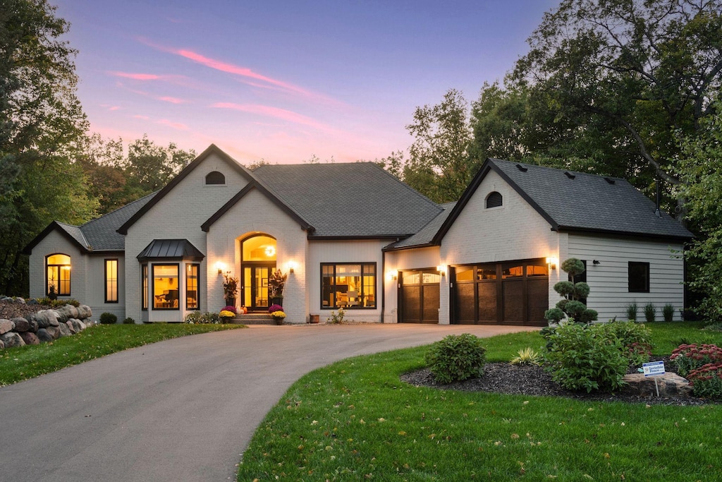 view of front of property with a garage, french doors, and a lawn