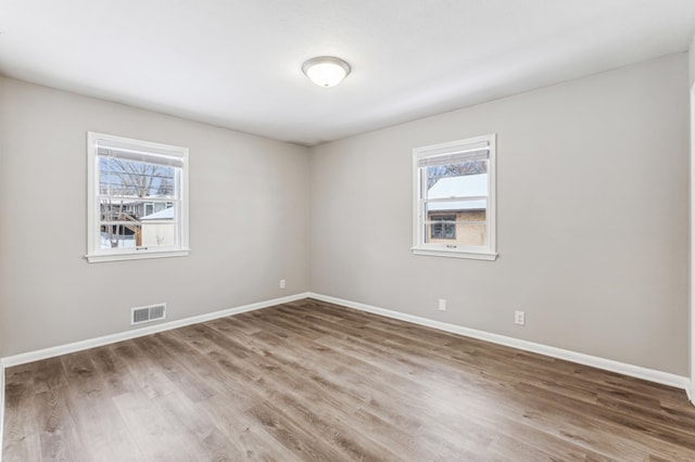 unfurnished room with wood-type flooring and a healthy amount of sunlight