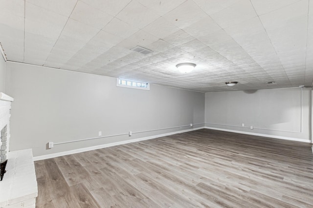 basement featuring hardwood / wood-style floors and a fireplace