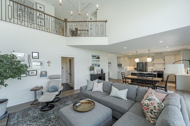 living room featuring baseboards, a chandelier, dark wood-style flooring, and recessed lighting