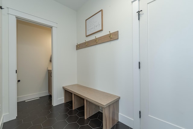 mudroom featuring dark tile patterned floors and baseboards