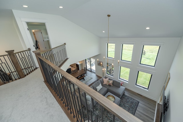 hall with lofted ceiling, recessed lighting, an upstairs landing, and an inviting chandelier