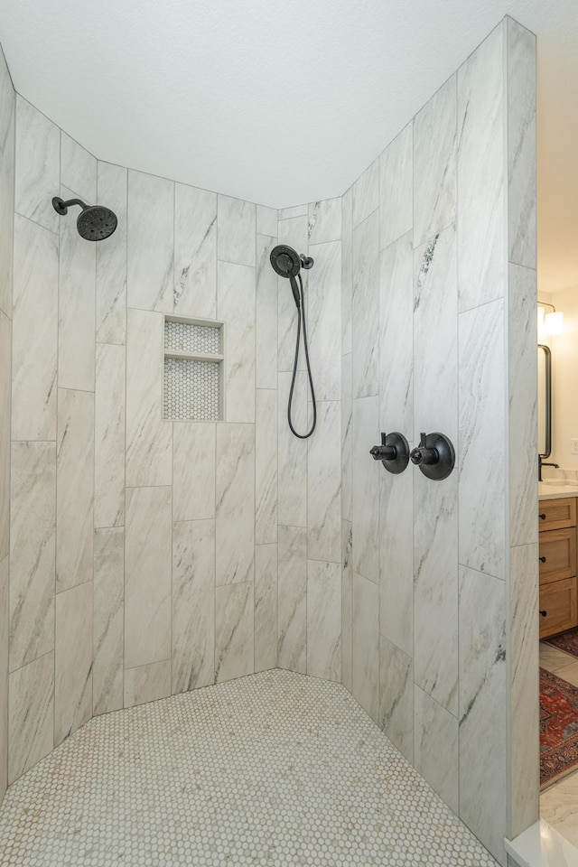 bathroom with a sink and tiled shower