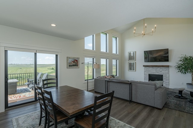 dining space featuring dark wood finished floors, a notable chandelier, a fireplace, and baseboards