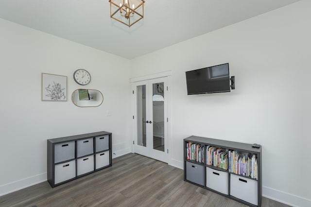 interior space featuring a notable chandelier, french doors, wood finished floors, and baseboards