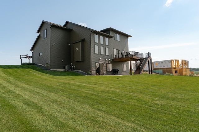 rear view of house featuring cooling unit, a yard, a deck, and stairs