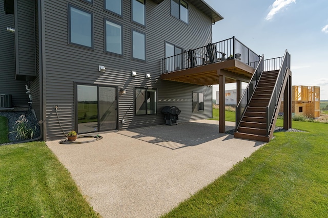 rear view of house featuring central air condition unit, a patio area, stairs, and a lawn