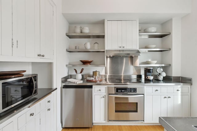 510 Groveland Ave Unit 502, Minneapolis, MN 55403 - kitchen with appliances with stainless steel finishes, stainless steel counters, open shelves, under cabinet range hood, and white cabinetry
