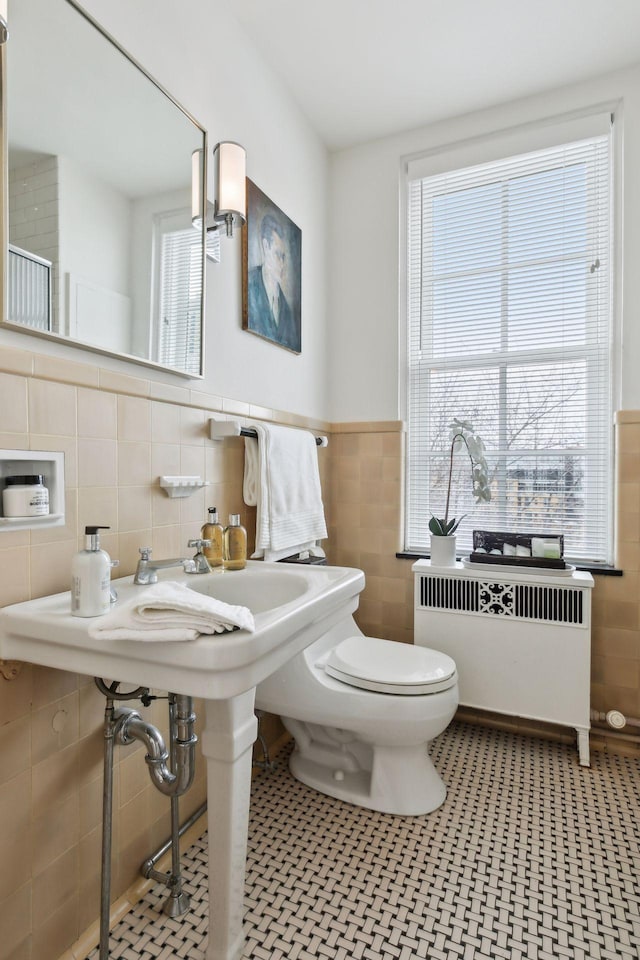 510 Groveland Ave Unit 502, Minneapolis, MN 55403 - bathroom with tile walls, radiator, toilet, and a wainscoted wall