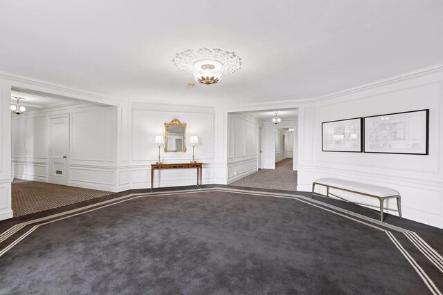 510 Groveland Ave Unit 502, Minneapolis, MN 55403 - unfurnished living room with a decorative wall, carpet flooring, crown molding, and a chandelier
