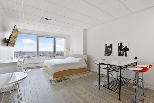 bedroom featuring a paneled ceiling and radiator