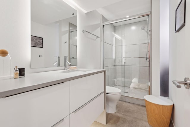 bathroom with a shower with door, vanity, and toilet