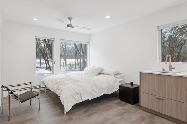 bedroom featuring ceiling fan and sink