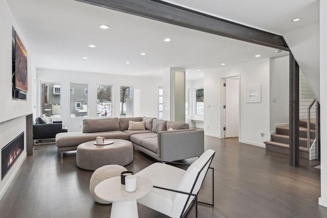 living room featuring beam ceiling and dark hardwood / wood-style floors