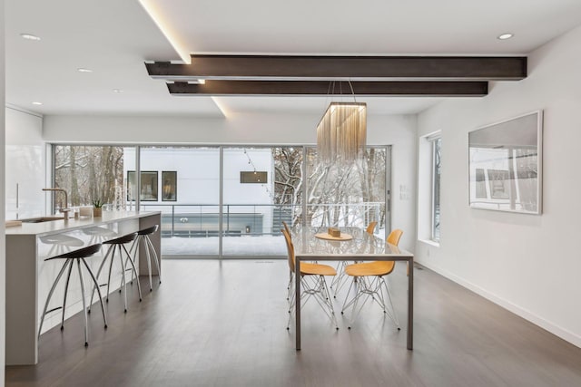 dining room with sink, hardwood / wood-style flooring, and beam ceiling