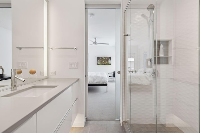 bathroom with ceiling fan, a shower with door, tile patterned flooring, and vanity