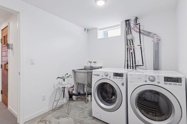 clothes washing area with separate washer and dryer and sink