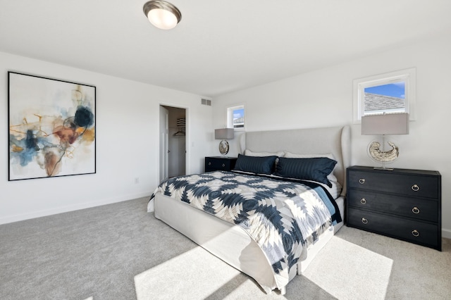 carpeted bedroom featuring a spacious closet and a closet