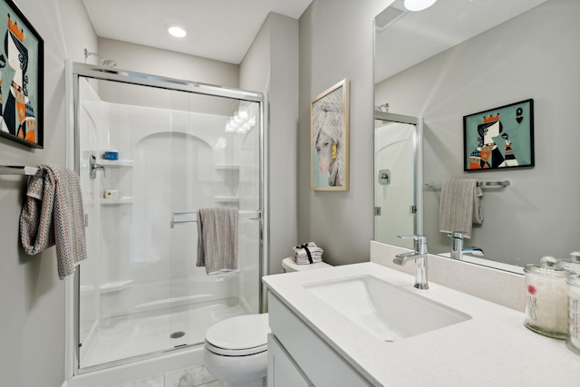 bathroom featuring toilet, vanity, and walk in shower